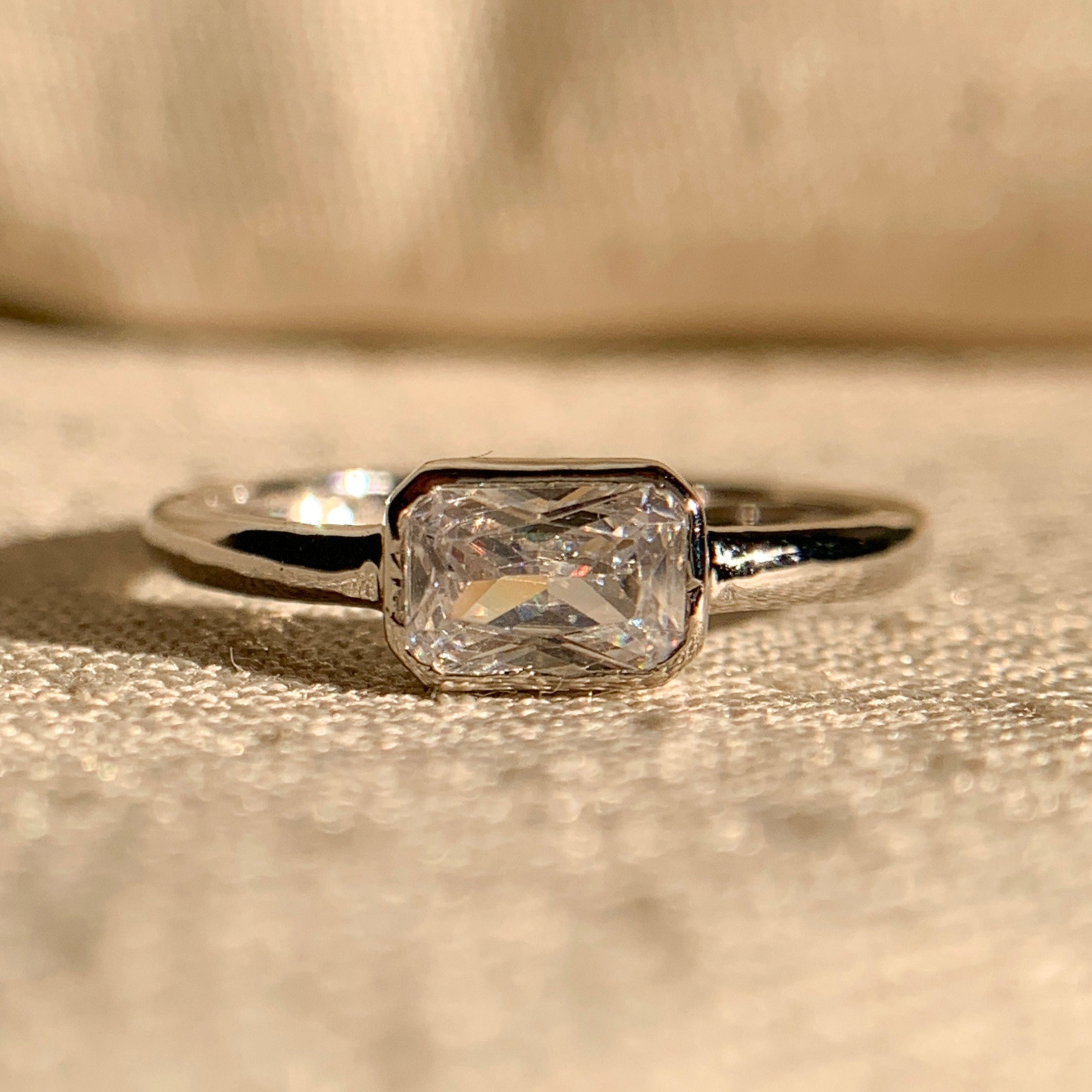 "East-West radiant cut solitaire engagement ring in white gold"